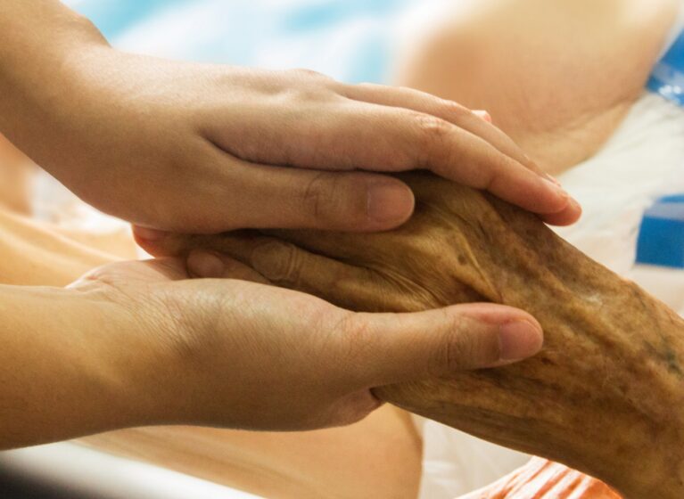 Healthcare provider holding patient's hand
