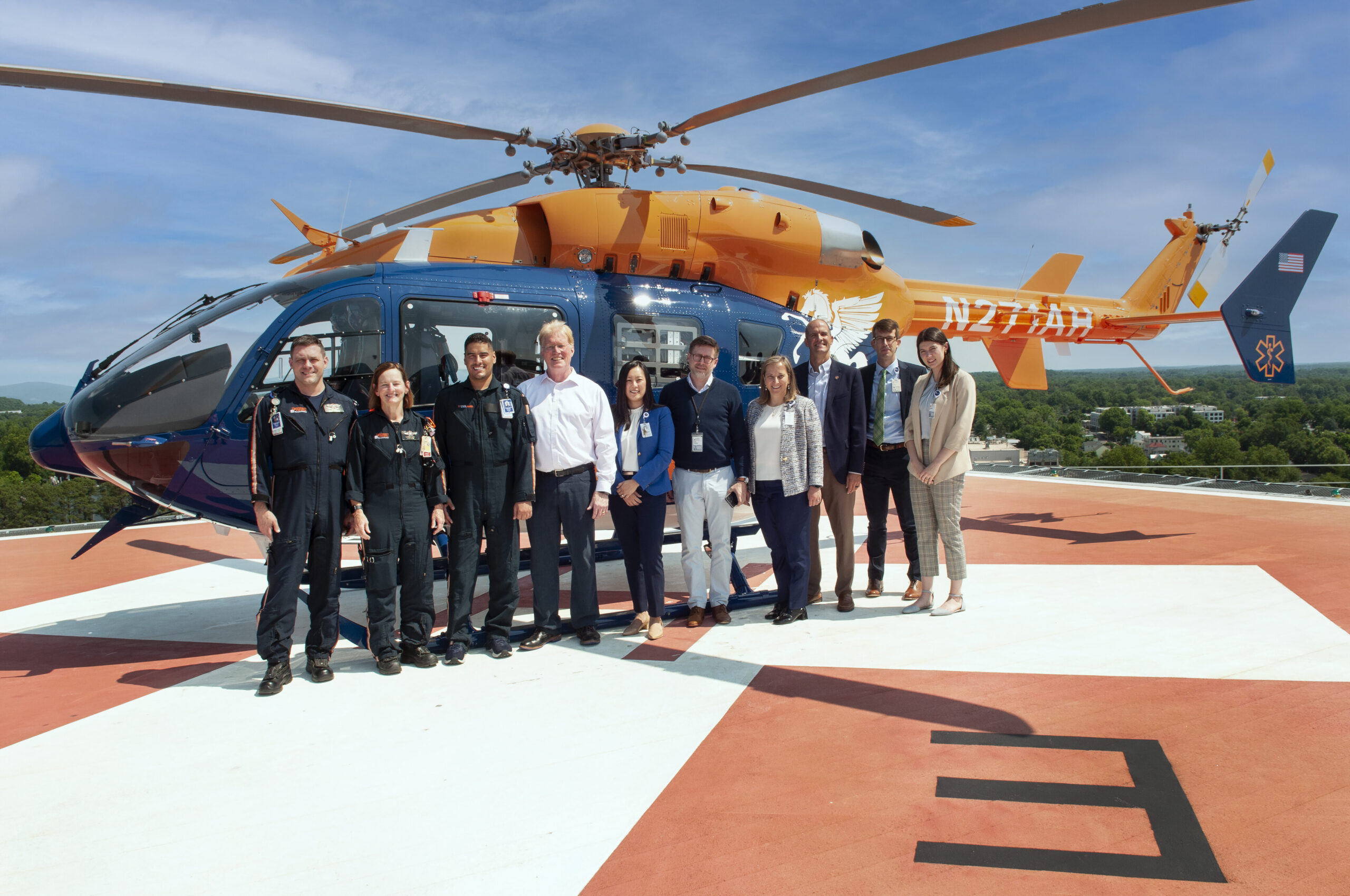 Group photo of UVA Health team members including leadership, Pegasus Air and the designer of the new helicopter